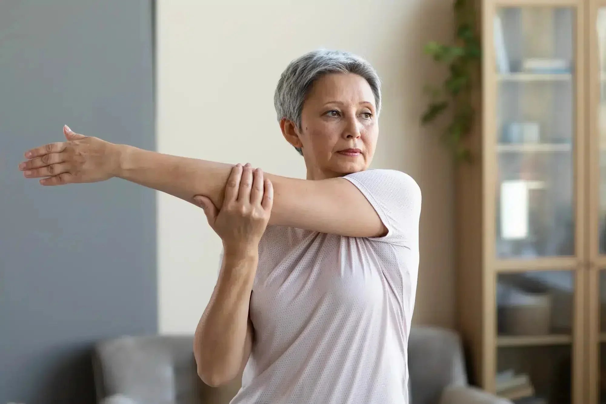 Femme faisant des étirements contre les douleurs articulaires de la ménopause