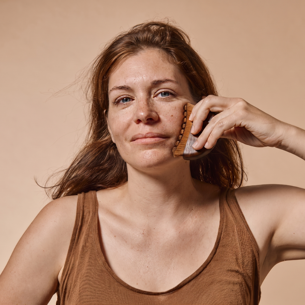 Une femme utilisant la brosse [MY] Brosse douce massante visage